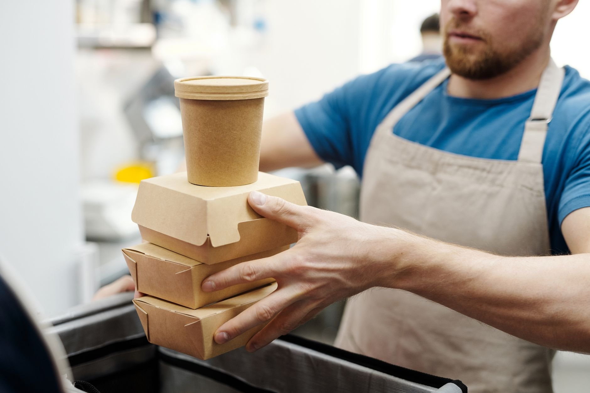 Stacked eco-friendly food containers being prepared for takeaway delivery in a kitchen